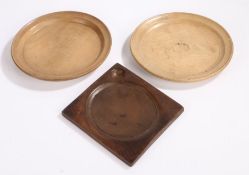 Two treen platters, to include a near pair 22cm wide and a trencher with a dished centre and a