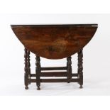 Mid 17th Century oak gateleg table, the oval drop leaf top above a moulded frieze and turned legs,