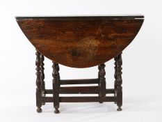 Mid 17th Century oak gateleg table, the oval drop leaf top above a moulded frieze and turned legs,