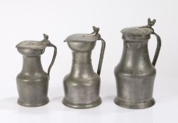 Three 18th/19th Century pewter flagons, Northern France, each with acorn finials above a hinged