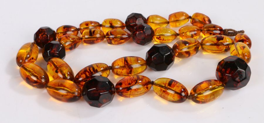 Amber bead necklace, with oval and facetted beads, 76cm long, 104.7g