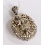 white metal pendant depicting a dancer on stage, opening to reveal two photographs of a lady and