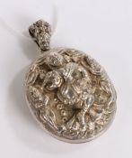 white metal pendant depicting a dancer on stage, opening to reveal two photographs of a lady and