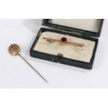 9 carat gold bar brooch set with a single garnet together with a yellow metal stick pin (2)
