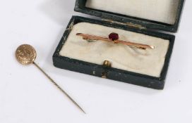 9 carat gold bar brooch set with a single garnet together with a yellow metal stick pin (2)