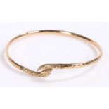 9 carat gold bangle in the form of a snake curled up with garnets for eyes, gross weight 6.0 grams