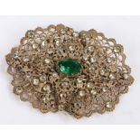 White metal and paste brooch set with a central green stone