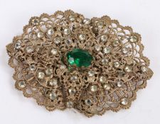 White metal and paste brooch set with a central green stone