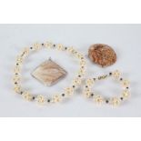Simulated pearl necklace and bracelet together with pendant formed out of a sea shell and another