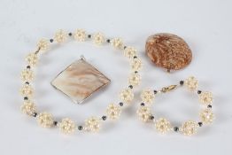 Simulated pearl necklace and bracelet together with pendant formed out of a sea shell and another