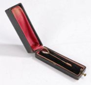 Gold coloured metal tie pin set with a teardrop shape garnet, 6.5cm long, housed in a maroon