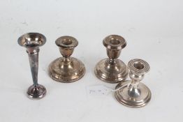 Three silver dwarf candlesticks, silver spill vase, various dates and makers, all with loaded