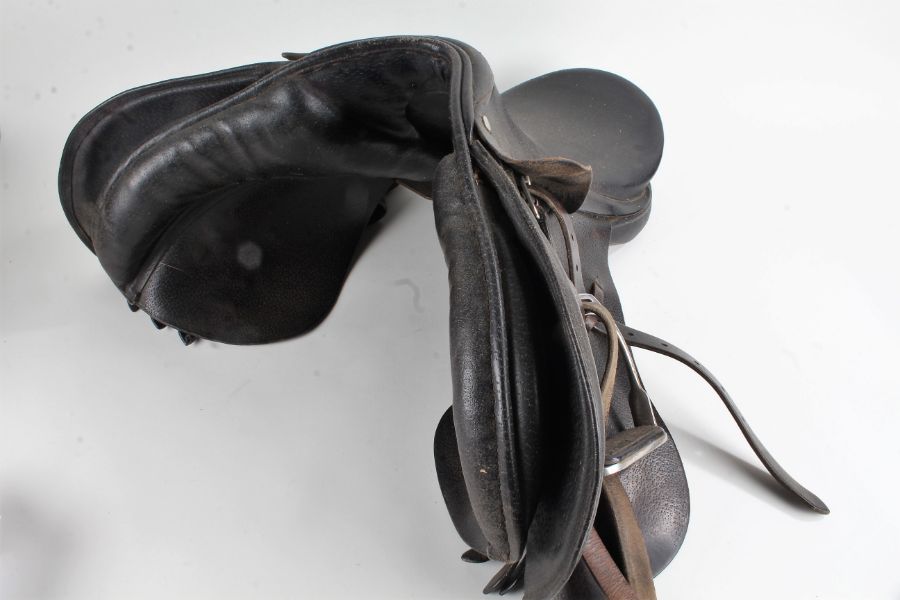 Black leather horse riding saddle, with a pair of stirrups