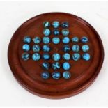 Mahogany solitaire board, with thirty-two glass marbles with blue swirls, the base bearing label for