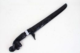 Oceanic hardwood knife, with a carved handle and scabbard, the blade marked Manap, 63cm long