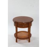 John Lewis Hemingway lamp table, having circular top above a single frieze drawer, with cane