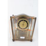 1960's/70's brass and glass clock, having shaped case and dial with Arabic numerals, 23.5cm high
