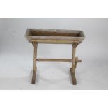 Rustic pine dug out trough on stand, united by a single stretcher, 91cm wide