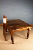Late Victorian extending dining table, with chamfered corners, raised on fluted legs and castors,