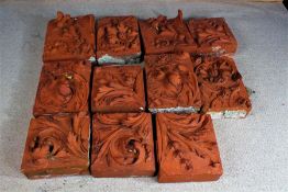 Eleven large terracotta plaques, 20th century, with foliate decoration, the largest 42cm x 35cm (11)