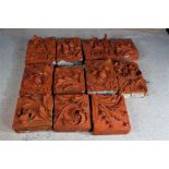 Eleven large terracotta plaques, 20th century, with foliate decoration, the largest 42cm x 35cm (11)