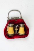 Pair of early 20th century ivorine opera glasses, housed in red velvet ladies evening purse