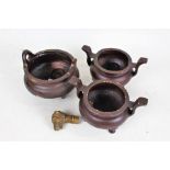 Three Chinese metal censers, each of cylindrical form, with carrying handles and raised on three