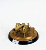 Brass cannon, on a brass and ebonised plinth base