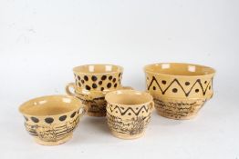 20th Century pottery slipware, to include a porringer, another and two cups, (4)