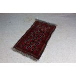 Middle Eastern prayer rug, the red ground with rosettes amongst stepped motifs, 53cm x 98cm