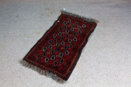 Middle Eastern prayer rug, the red ground with rosettes amongst stepped motifs, 53cm x 98cm