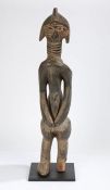 Sierra Leone Mende standing figure, the head with carved linear decorations, above a ringed neck,