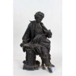 Cast lead figure depicting a scholarly gentleman leaning on a pedestal reading a book, 42cm high