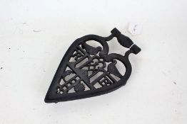 Cast iron masonic trivet, with depictions of interlocked hands, birds, sun, moon and initials RB,