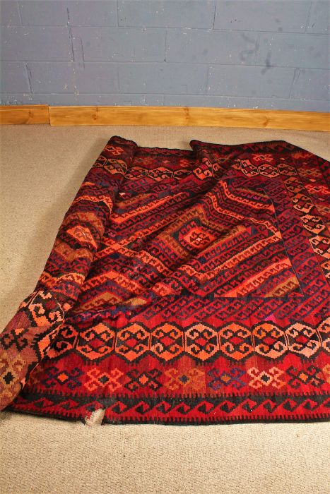 Mushwani Baluch rug, the red ground with multiple lozenges in green, black and orange, 270cm x 198cm