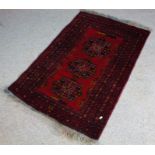 Persian rug, the red ground with three Heriz medallions, within multiple geometric borders, 123cm