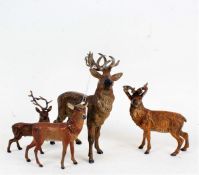 Three various cast metal painted stags, and a deer similar, the largest 23cm high