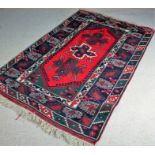 Kazak South Caucacus rug, the red and olive field with three lozenges and foliate motifs, within a