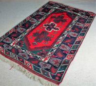 Kazak South Caucacus rug, the red and olive field with three lozenges and foliate motifs, within a