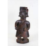 Eastern naive carved standing figure, in the form of a man wearing a tunic, 42.5cm high