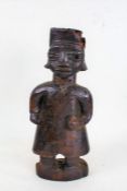 Eastern naive carved standing figure, in the form of a man wearing a tunic, 42.5cm high