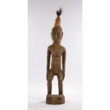 Large Mali Dogon carved figure, with high hair above the elongated face, hands to the waist and bent