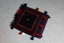 Persian salt bag, the blue field with motifs, within a red geometric border, flanked by tassels,