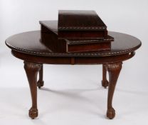 Early 20th Century mahogany extending dining table, the oval top with carved edge above acanthus