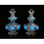 Pair of 19th Century glass decanters, the later stoppers above a shaped body with blue glass domes