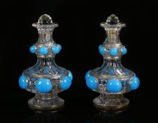 Pair of 19th Century glass decanters, the later stoppers above a shaped body with blue glass domes