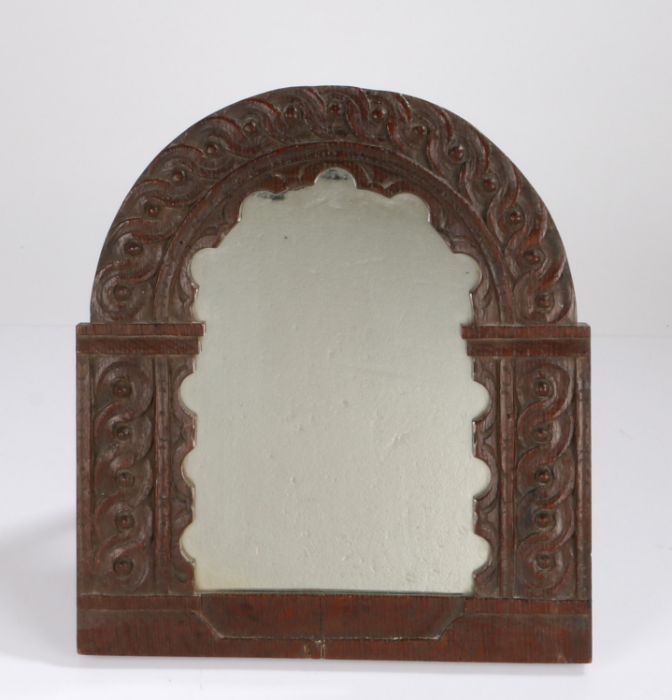 18th Century oak panel, now mounted as a looking glass, with arched scroll carved top and sides,