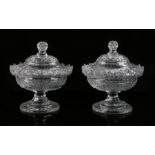 Pair of cut glass sweet meats, with angled finials above an oval lidded body and facetted stemmed