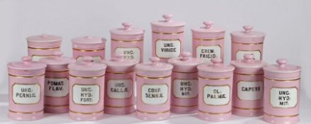 Fifteen puce porcelain apothecary jars, the white and gilt bordered labels with black lettering,