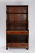 Regency style mahogany waterfall bookcase, the gallery top above four tiered shelves and two drawers
